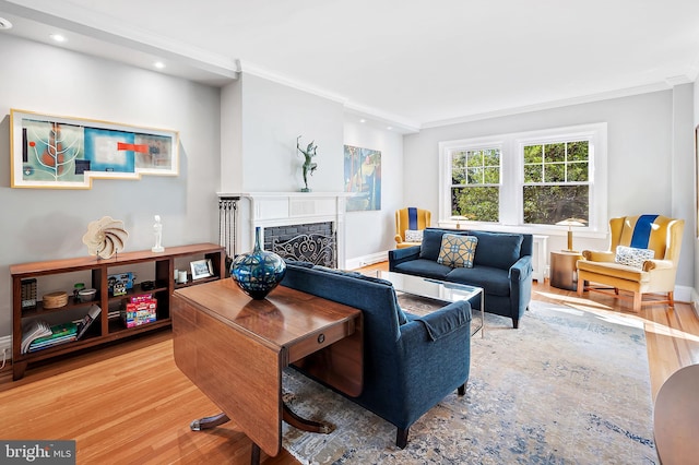 living room with ornamental molding, a fireplace, wood finished floors, and baseboards