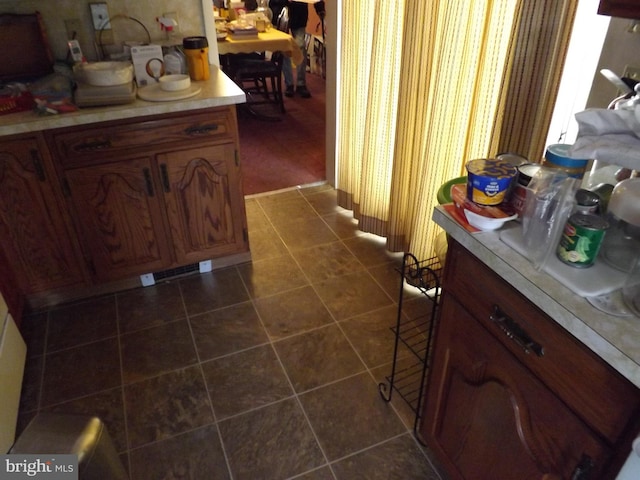 interior space featuring light countertops and dark tile patterned flooring