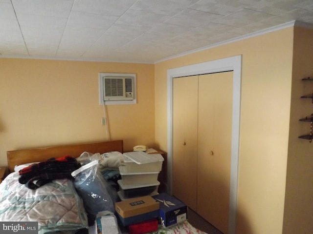 bedroom featuring a wall mounted AC, a closet, and crown molding