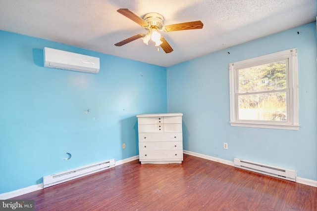 spare room with a textured ceiling, a baseboard radiator, wood finished floors, and a wall mounted air conditioner