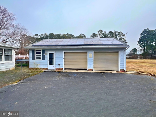 view of front facade with a detached garage and solar panels