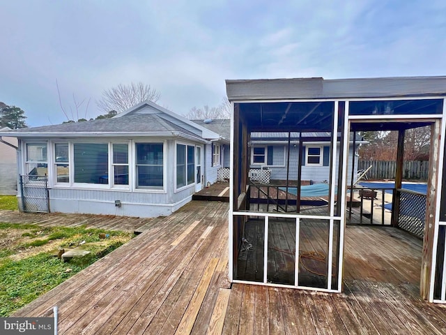 back of property with fence and a wooden deck