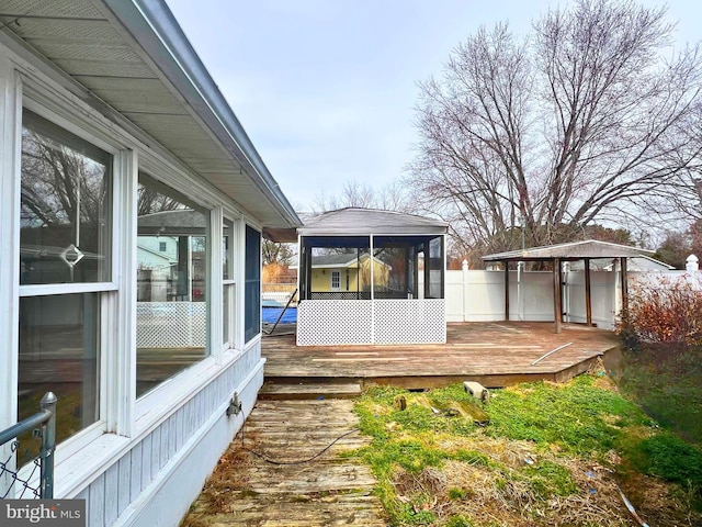 wooden deck with fence and a sunroom