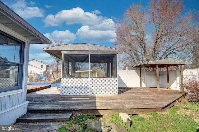 deck featuring a sunroom and fence