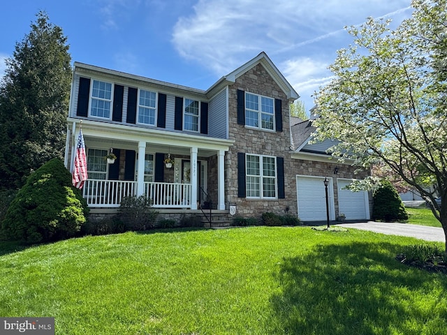 traditional home with a front lawn, an attached garage, driveway, stone siding, and a porch
