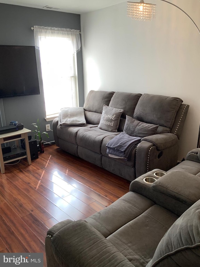 living area featuring visible vents and wood finished floors