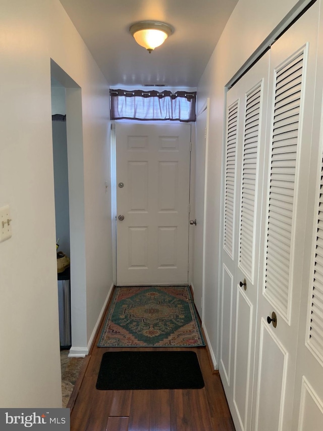 doorway to outside with baseboards and wood finished floors