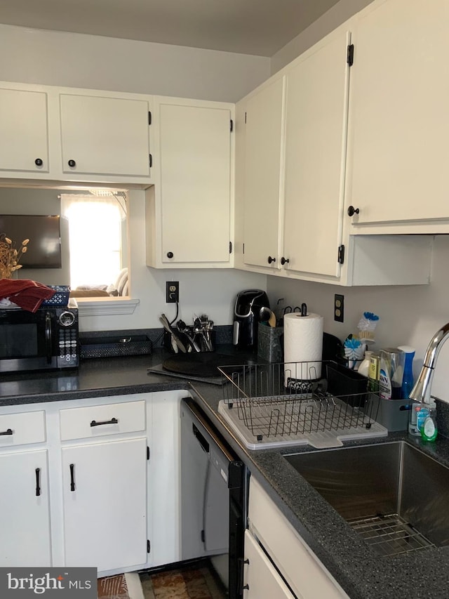 kitchen featuring white cabinetry, black appliances, dark countertops, and a sink