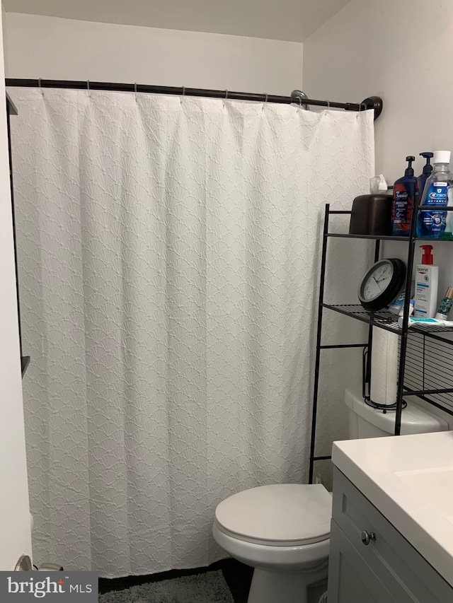 full bathroom featuring curtained shower, toilet, and vanity