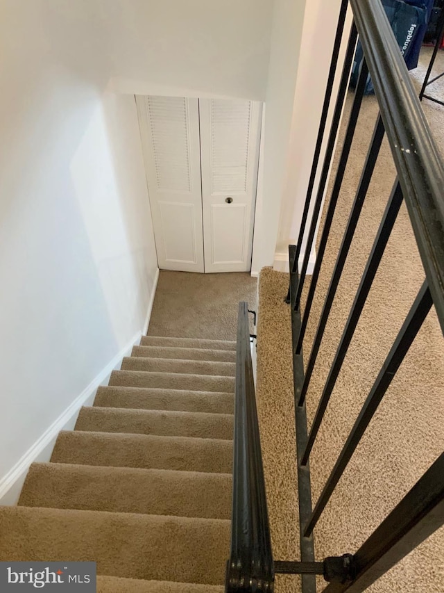 stairs featuring baseboards and carpet floors