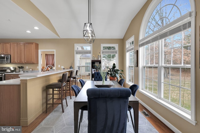 13110 Ogles Hope Dr, Bowie, MD 20720 - dining room with light wood-style floors, visible vents, vaulted ceiling, and baseboards