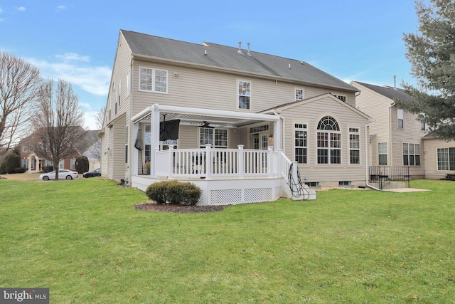 rear view of property featuring a lawn, a wooden deck, and a pergola