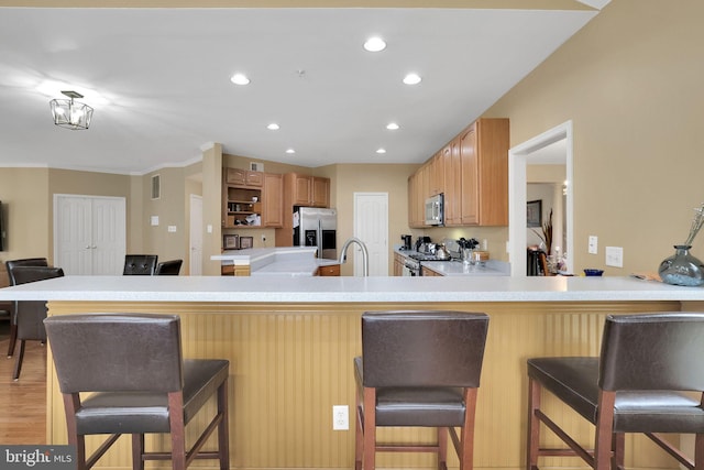 13110 Ogles Hope Dr, Bowie, MD 20720 - kitchen featuring a kitchen breakfast bar, a peninsula, light countertops, and stainless steel appliances