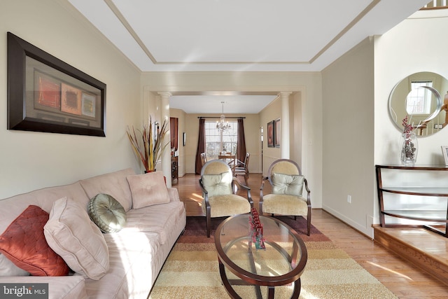 13110 Ogles Hope Dr, Bowie, MD 20720 - living room with a chandelier, baseboards, light wood finished floors, and ornate columns