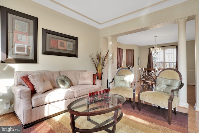 13110 Ogles Hope Dr, Bowie, MD 20720 - living room featuring ornamental molding, wood finished floors, decorative columns, and an inviting chandelier