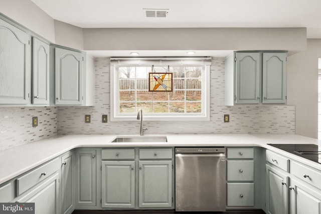 kitchen featuring tasteful backsplash, visible vents, light countertops, stainless steel dishwasher, and a sink