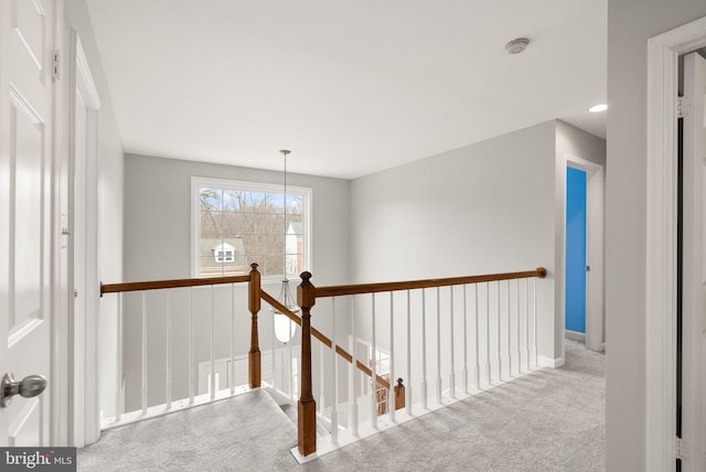 hallway featuring carpet and an upstairs landing