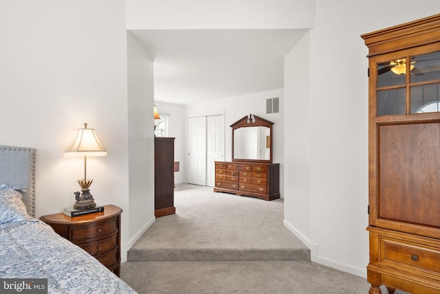 bedroom with carpet floors, a closet, visible vents, and baseboards