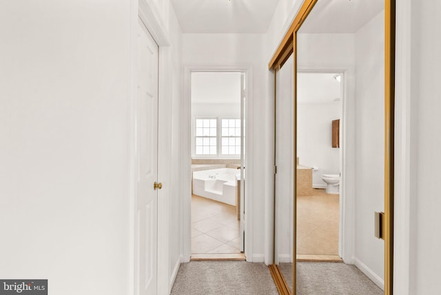 hallway featuring carpet floors and tile patterned flooring