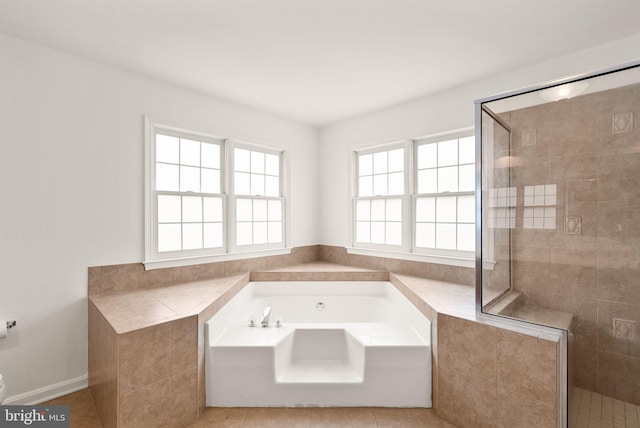 bathroom with a stall shower, a bath, and tile patterned floors