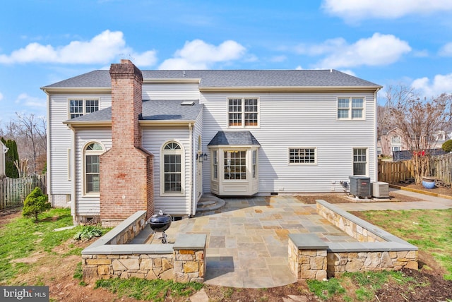 back of property with a patio, central AC unit, a chimney, and fence