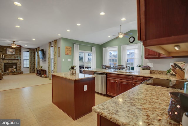 kitchen with a center island, a fireplace, open floor plan, light stone countertops, and dishwasher