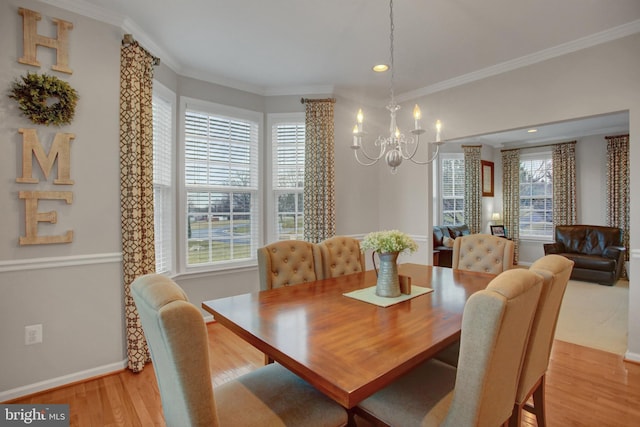 dining area with a chandelier, crown molding, baseboards, and light wood-style floors