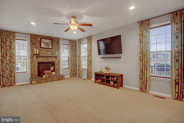 carpeted living area featuring a healthy amount of sunlight, a fireplace, baseboards, and recessed lighting