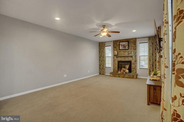 unfurnished living room with recessed lighting, light carpet, a fireplace, a ceiling fan, and baseboards