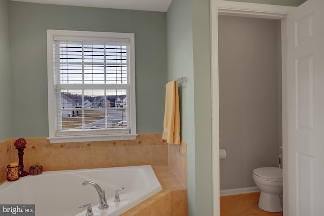 full bathroom featuring baseboards, a garden tub, toilet, and tile patterned floors