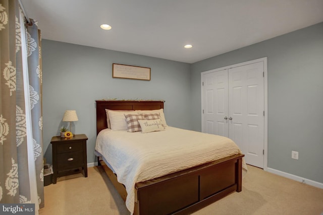 bedroom with recessed lighting, a closet, light carpet, and baseboards