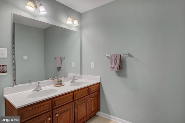 full bathroom with double vanity, a sink, and baseboards