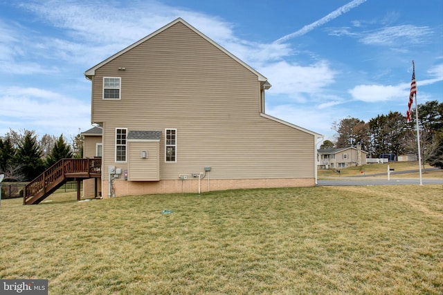 view of side of property featuring a yard, stairway, and a wooden deck