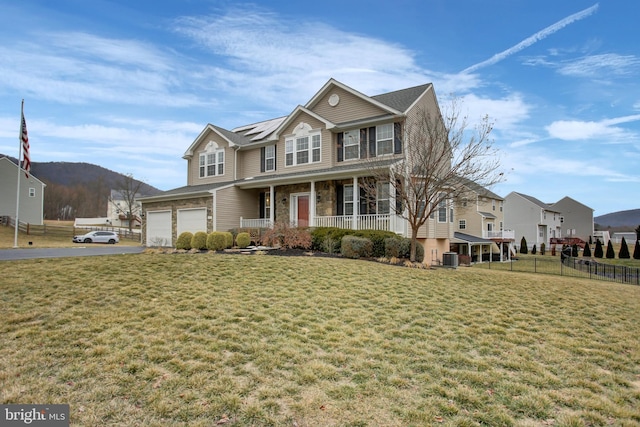 view of front of home featuring a porch, a front lawn, fence, and aphalt driveway