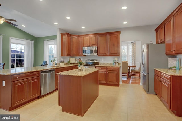 kitchen featuring a peninsula, appliances with stainless steel finishes, plenty of natural light, and a sink