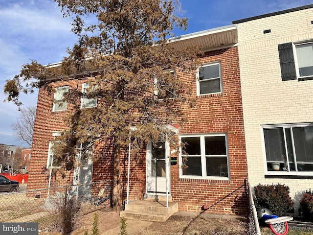 townhome / multi-family property with brick siding and fence