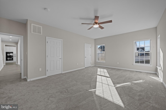 unfurnished bedroom featuring ceiling fan, carpet floors, visible vents, and baseboards