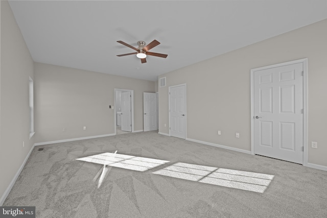 unfurnished bedroom with a ceiling fan, light colored carpet, visible vents, and baseboards