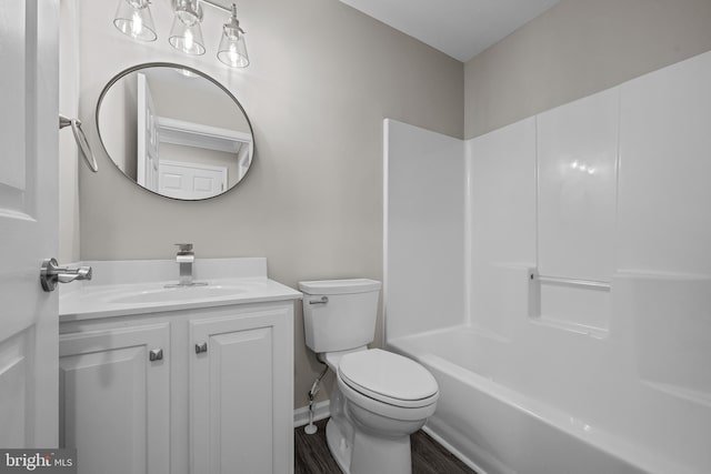 full bathroom with toilet, wood finished floors, vanity, baseboards, and  shower combination