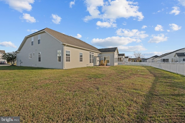 back of house featuring fence and a yard