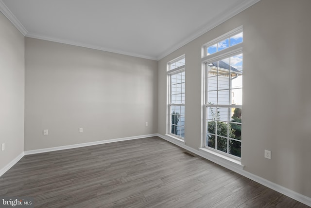 unfurnished room with ornamental molding, baseboards, and wood finished floors