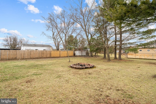 view of yard featuring a fenced backyard and a fire pit