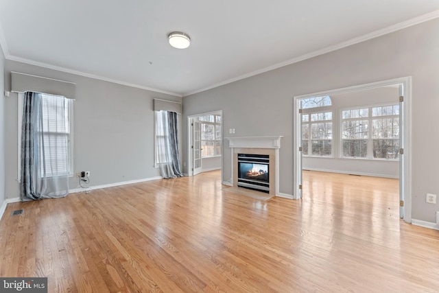 unfurnished living room with visible vents, light wood-type flooring, a multi sided fireplace, and ornamental molding