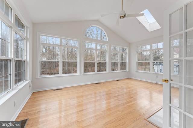 unfurnished sunroom with visible vents, vaulted ceiling with skylight, and a ceiling fan