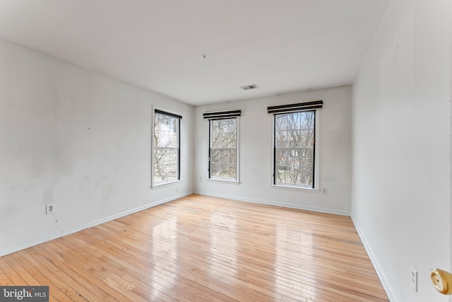 unfurnished room with baseboards and wood-type flooring