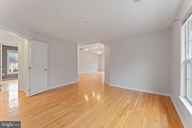 unfurnished room with light wood-style flooring and baseboards