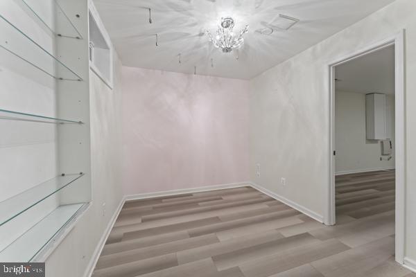 walk in closet with wood finished floors