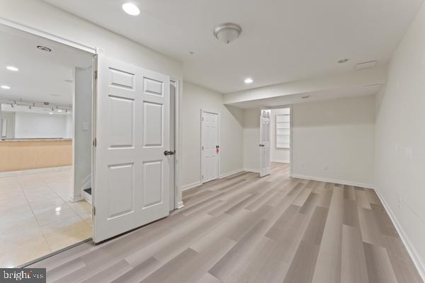 unfurnished room featuring recessed lighting, baseboards, and light wood-type flooring