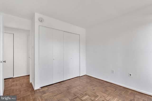 unfurnished bedroom with a closet and baseboards