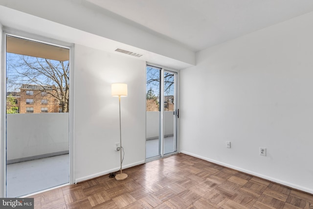 unfurnished bedroom featuring access to outside, visible vents, baseboards, and multiple windows